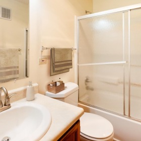 a bathroom with a glass shower, toilet and sink